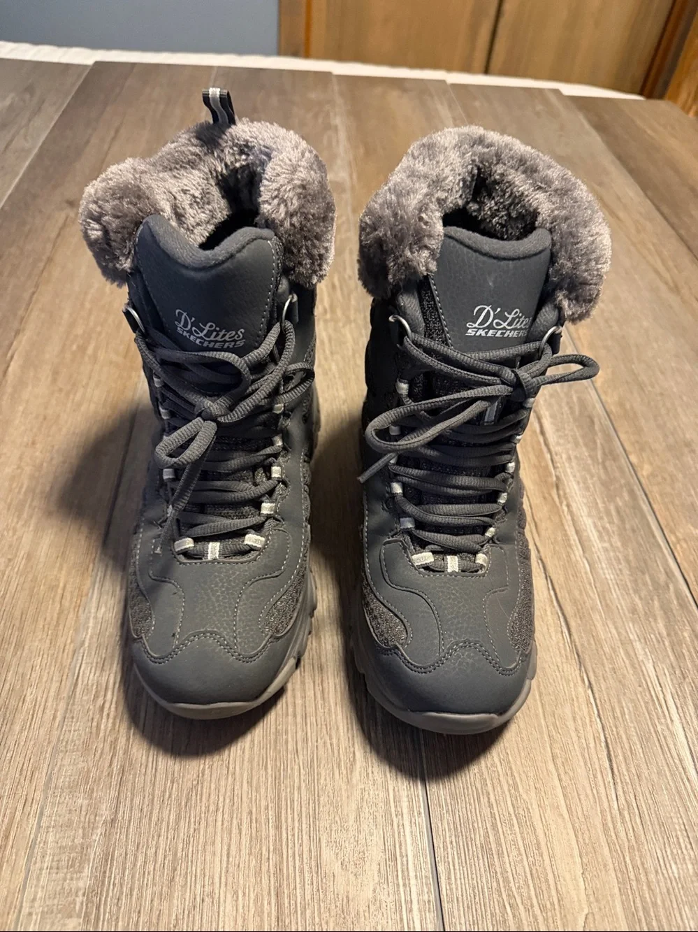 Skechers D'Lites Bomb Cyclone winter boots in a charcoal color, featuring a faux
